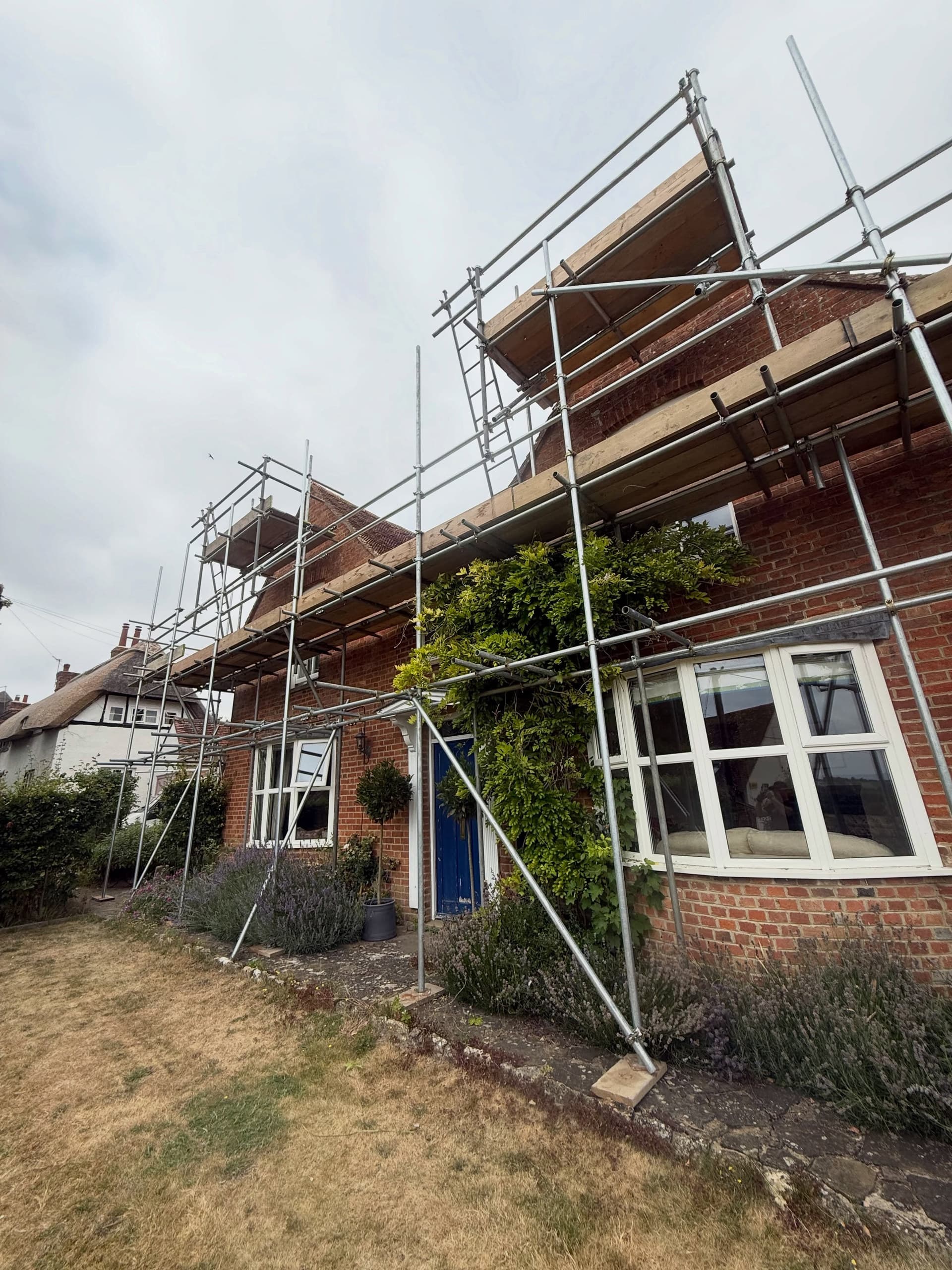 Cottage gable end with scaffold to the ridge