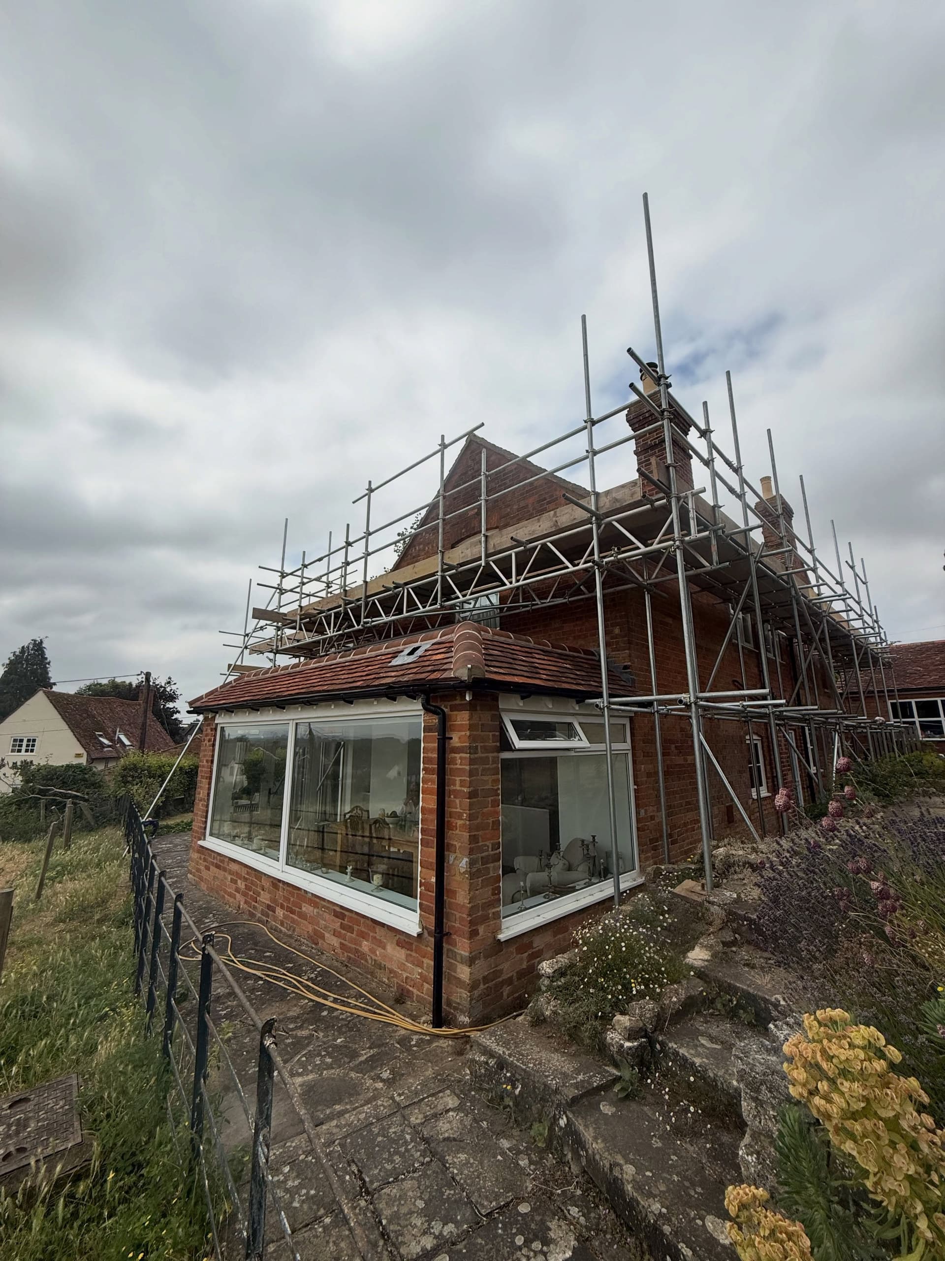 Period farmhouse corner with scaffold over the roof