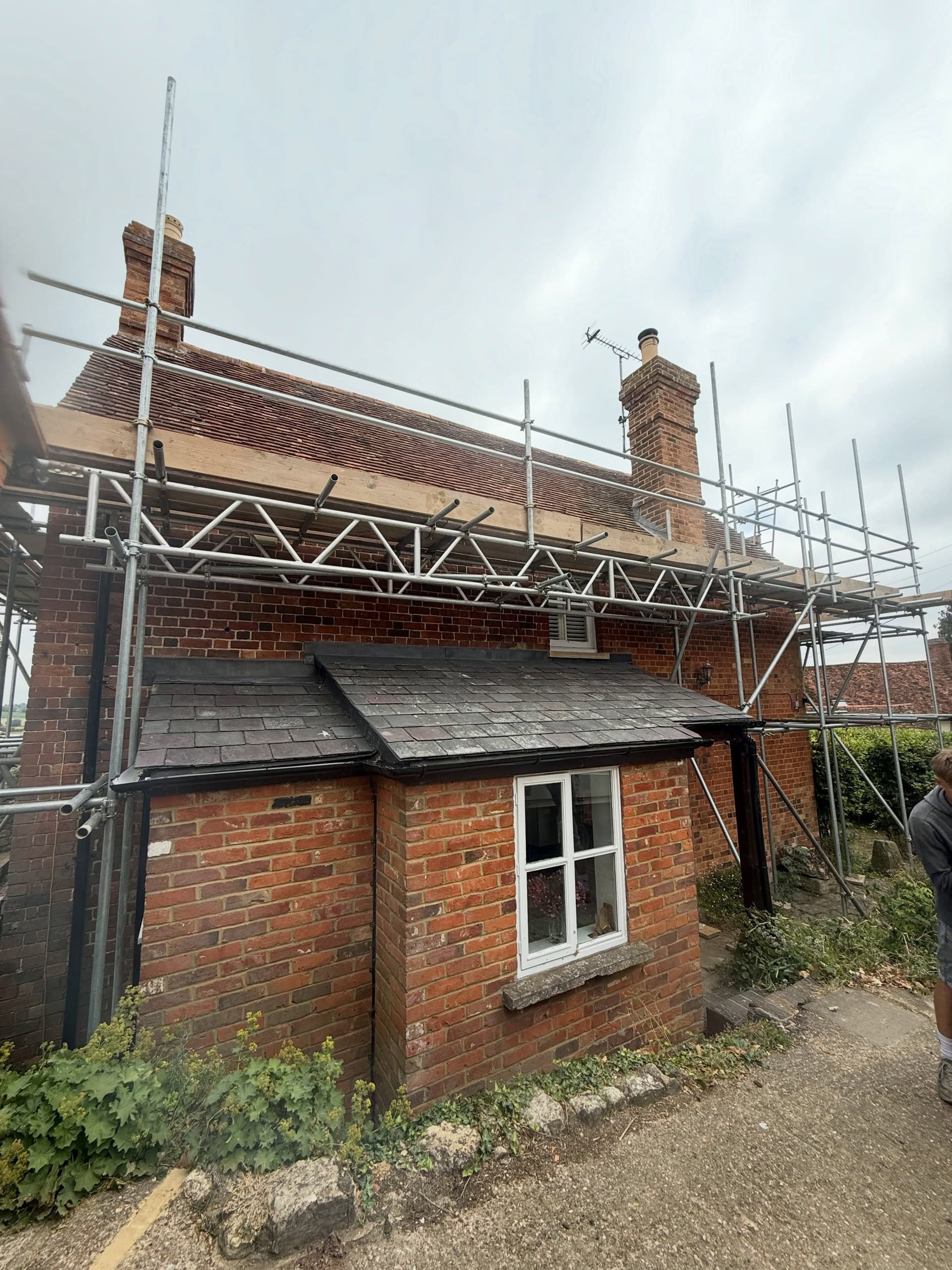 Rear of a period farmhouse with scaffold up to both chimneys
