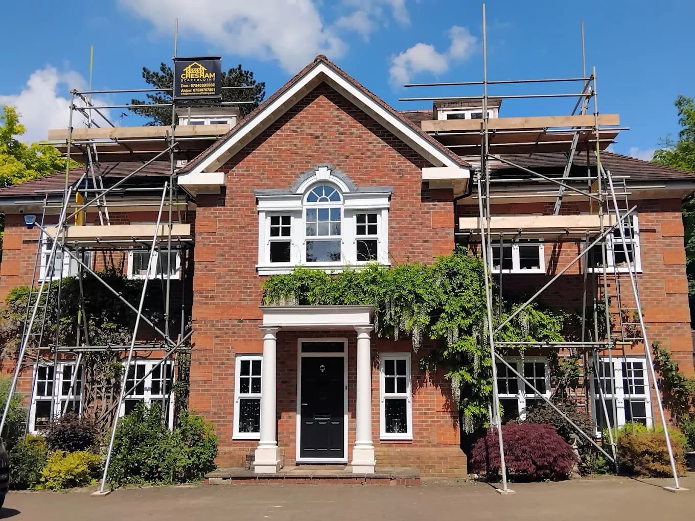 Symmetrical Georgian-style detached house with scaffold either side of the porch