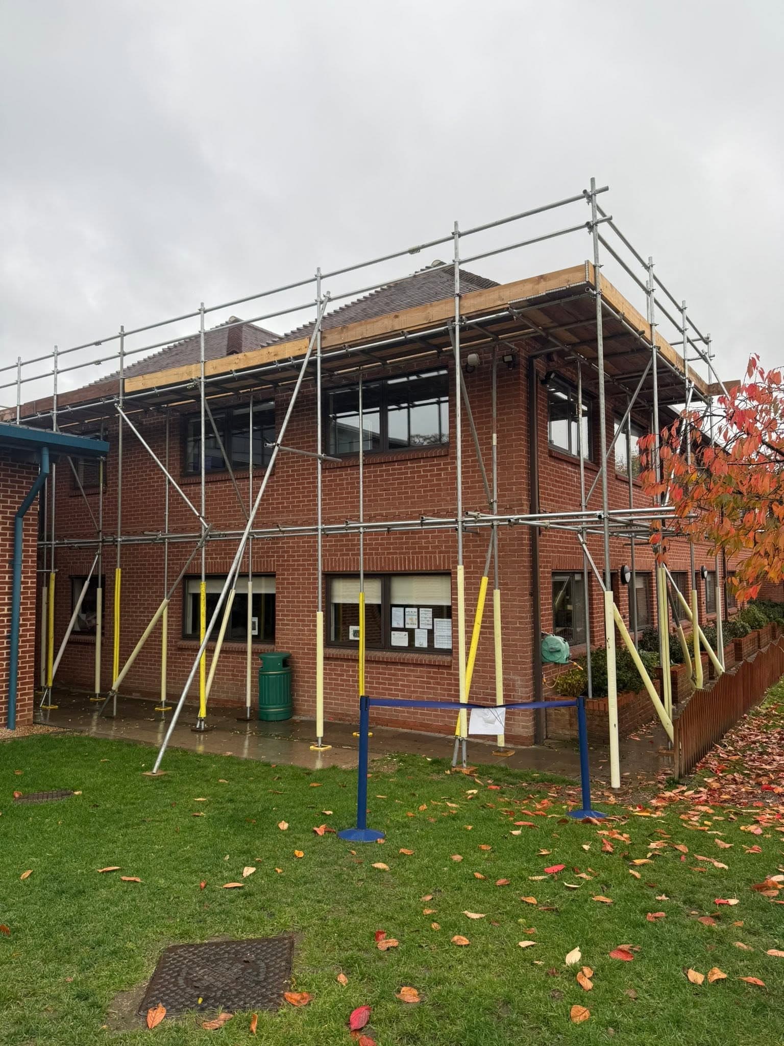 Two-storey office block with full scaffold and yellow tube guards